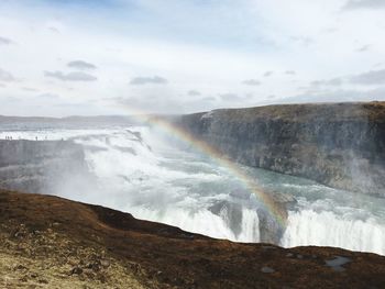 Scenic view of waterfall against sky