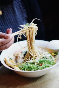 Cropped image of hand holding naksa with chopsticks