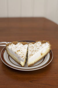 Two slices of lemon meringue pie on plate