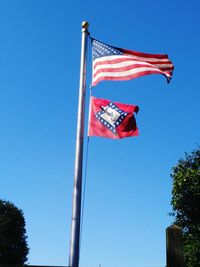 Low angle view of american flag against blue sky