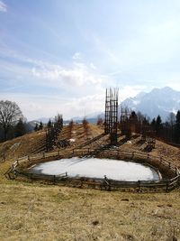 Mountain field with lake against sky