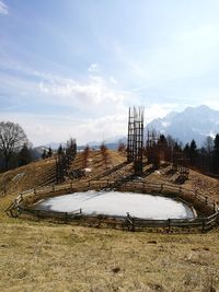 Mountain field with lake against sky