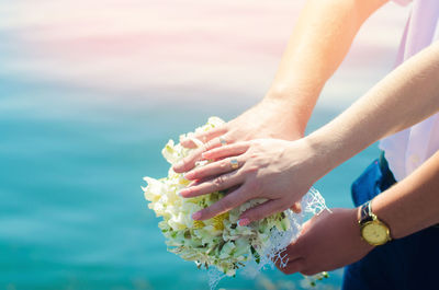 Close-up bride and groom's hands with wedding rings and bouquet. love and marriage.