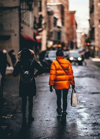 Rear view of people walking on street