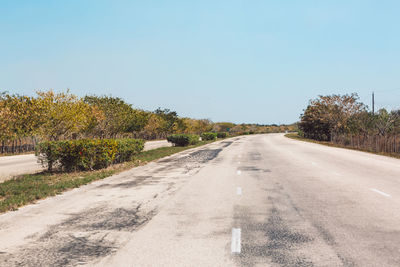 Road amidst trees against clear sky