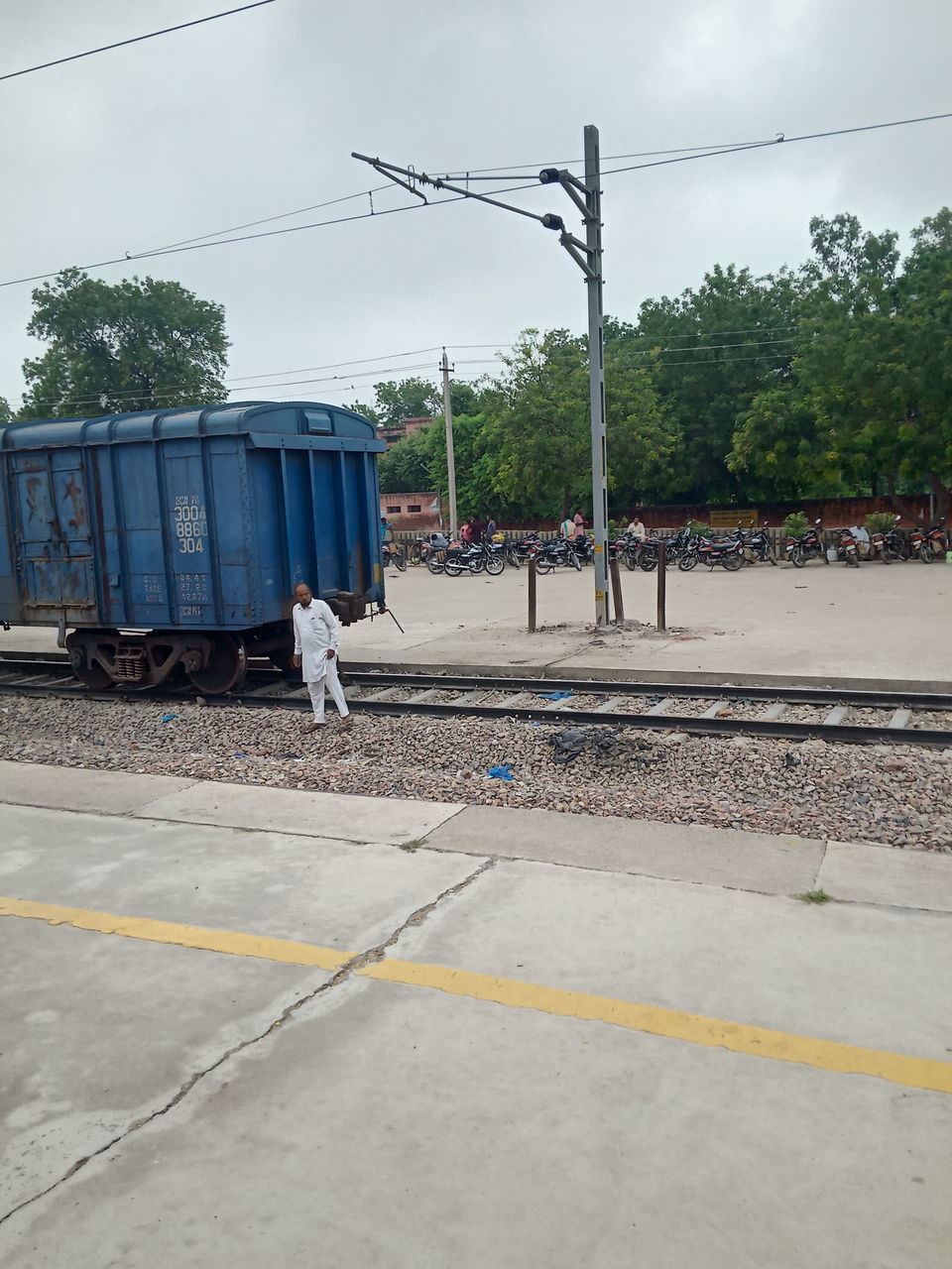 REAR VIEW OF MAN ON RAILROAD TRACKS