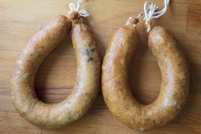 Top view of portuguese smoked sausage called alheira on wooden board