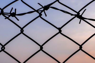 Low angle view of chainlink fence against sky