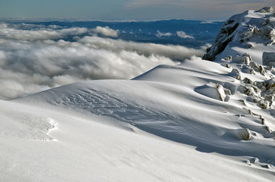 Snow covered landscape against sky