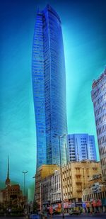 Low angle view of modern buildings against blue sky