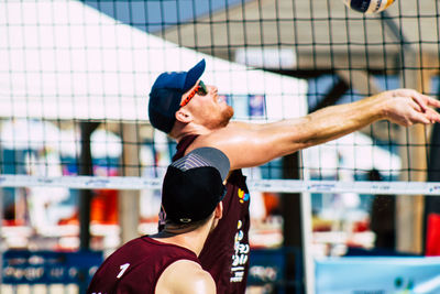 Midsection of man with arms raised against blurred background