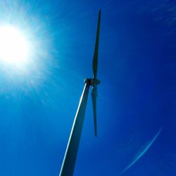 Low angle view of windmill against blue sky