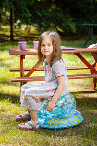 Portrait of girl sitting on balloon in park