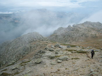 Man standing on mountain against sky
