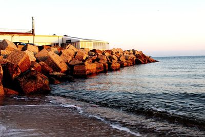 Panoramic shot of rocks on sea against clear sky