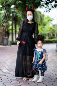 Mother and little girl in halloween costume standing outdoor