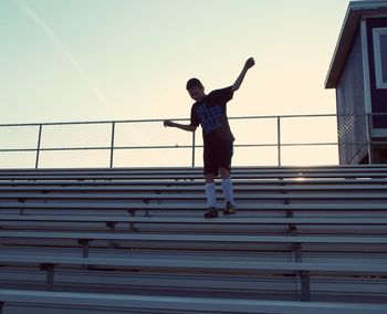 Low angle view of boy on bleachers