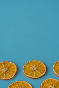 Flat layout of a dried orange fruit slices on a blue background