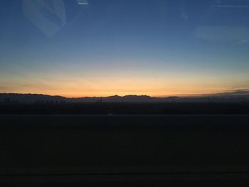 Silhouette landscape against sky during sunset