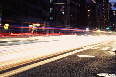 Light trails on road along buildings at night