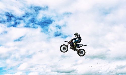Low angle view of man riding motorcycle against sky