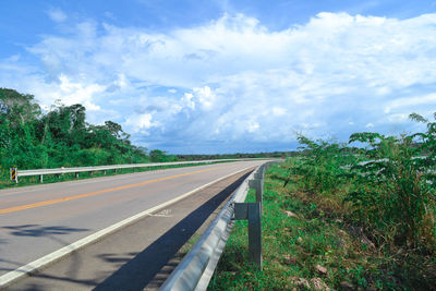 Road by trees against sky