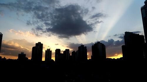 Silhouette buildings against sky during sunset