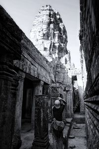 Rear view of woman in old building against sky