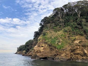 Rock formations by sea against sky