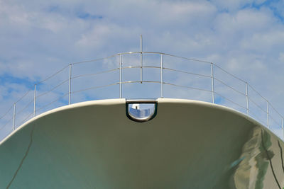 Low angle view of metallic ship structure against sky