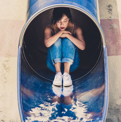 Young woman sitting on slide
