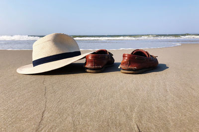 Lounge chairs on sand at beach against sky