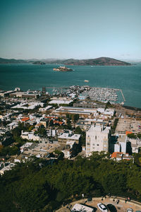 High angle view of townscape by sea against sky