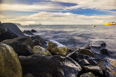 Rocks on sea shore against sky