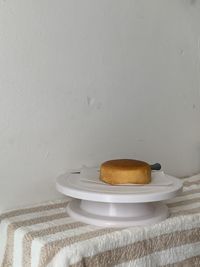 Close-up of breakfast served on table against wall