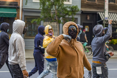 Rear view of people walking on street in city