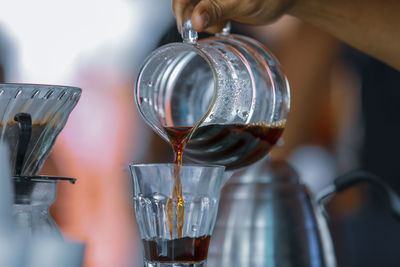 Close-up of hand pouring wine in glass