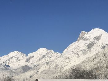 Scenic view of snowcapped mountains against clear blue sky