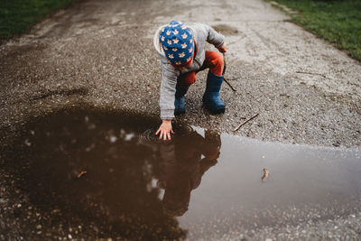 Reflection of boy in puddle