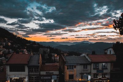 Residential district against sky at sunset