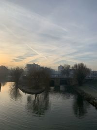 Scenic view of river against sky at sunset