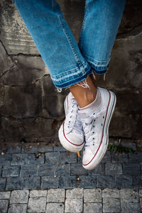 Low section of woman standing on footpath