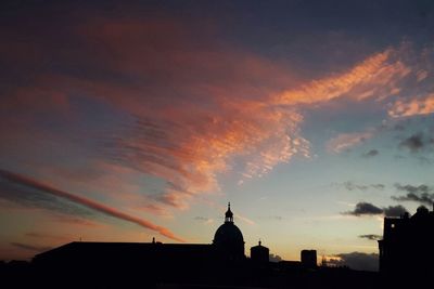 Silhouette city against sky during sunset