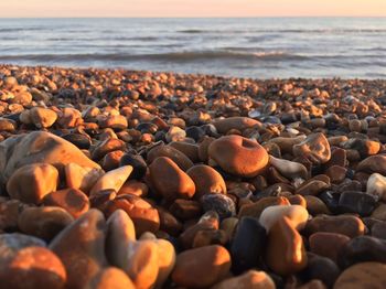 View of pebbles at beach during sunset