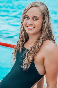 Portrait of beautiful young woman by swimming pool