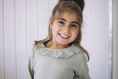 Portrait of happy girl in classroom at kindergarten