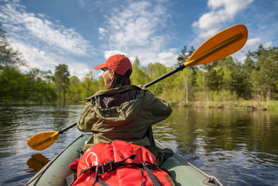 Rear view of woman kayaking in river
