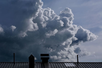 Low angle view of railing against cloudy sky