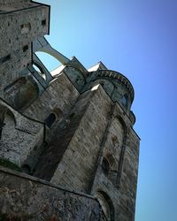 Low angle view of old building against clear blue sky