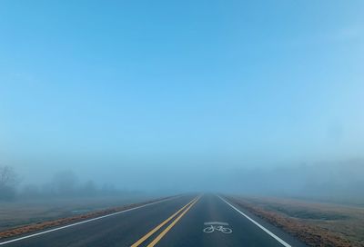 Road disappearing amidst fog during winter